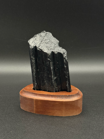 Schwarzer Turmalin Rohstein auf Holzsockel